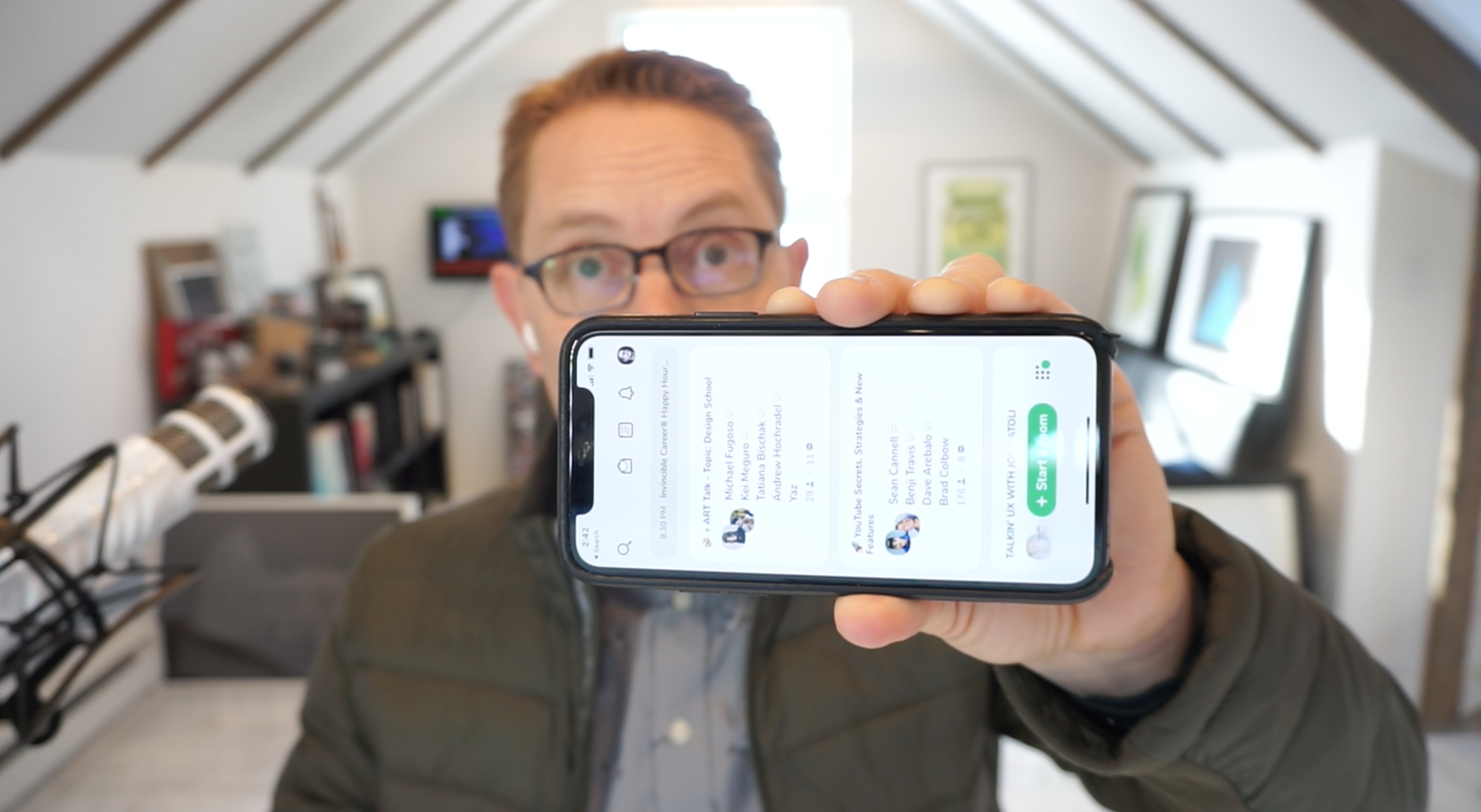 me holding up a phone with the Clubhouse app on screen